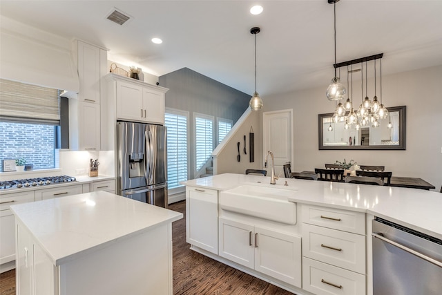 2758 Sharlis Dr, Frisco, TX 75036 - kitchen featuring appliances with stainless steel finishes, a sink, dark wood finished floors, decorative light fixtures, and white cabinets