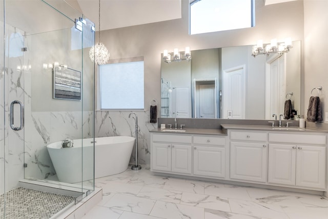 2758 Sharlis Dr, Frisco, TX 75036 - bathroom with marble look tile flooring, double vanity, a chandelier, plenty of natural light, and tile walls