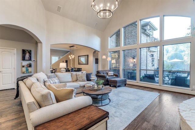 2758 Sharlis Dr, Frisco, TX 75036 - living room with a chandelier, arched walkways, high vaulted ceiling, and wood finished floors