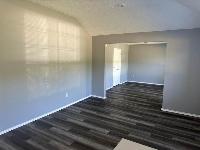 1512 Straus Rd, Cedar Hill, TX 75104 - spare room featuring lofted ceiling, baseboards, dark wood-style floors, and a textured ceiling