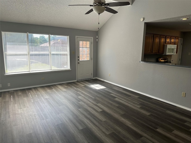 1512 Straus Rd, Cedar Hill, TX 75104 - unfurnished living room featuring a ceiling fan, dark wood-style floors, lofted ceiling, a textured ceiling, and baseboards