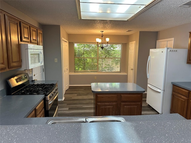 1512 Straus Rd, Cedar Hill, TX 75104 - kitchen with white appliances, dark wood finished floors, a chandelier, brown cabinets, and dark countertops