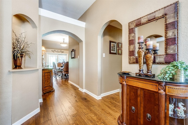 140 Daisey Ln, Justin, TX 76247 - hallway featuring arched walkways, light wood-style flooring, and baseboards