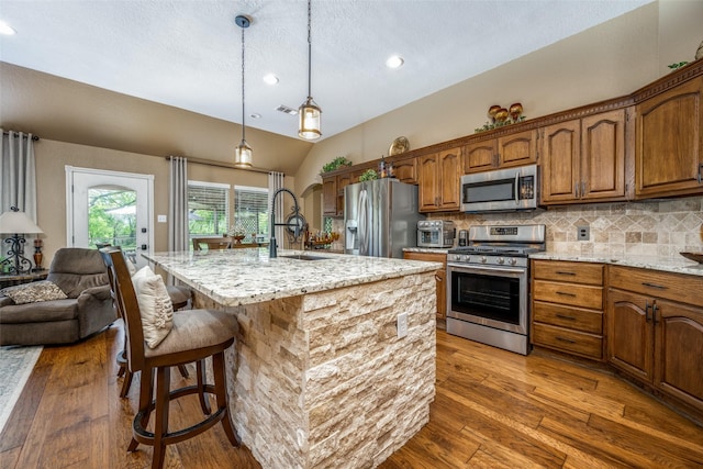 140 Daisey Ln, Justin, TX 76247 - kitchen with stainless steel appliances, decorative backsplash, brown cabinets, recessed lighting, and vaulted ceiling