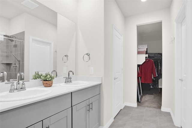 4925 Westhill Dr, Princeton, TX 75071 - bathroom with double vanity, a shower stall, a spacious closet, baseboards, and tile patterned flooring