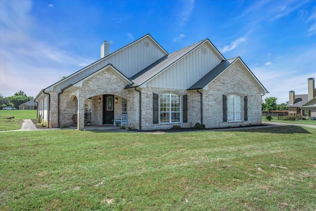 552 Heritage Ct, Canton, TX 75103 - french country home featuring a front yard, a chimney, a porch, and brick siding