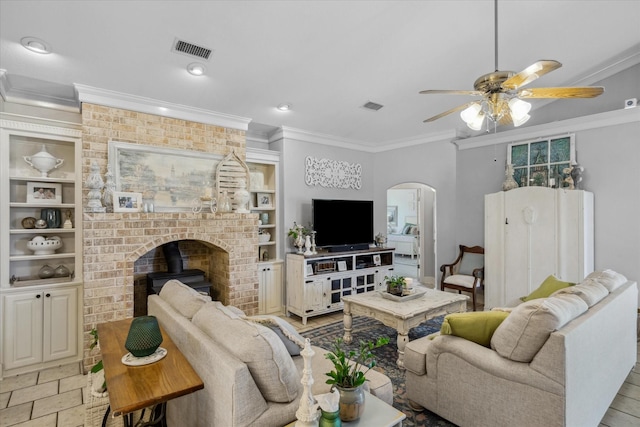 552 Heritage Ct, Canton, TX 75103 - living room with a wood stove, crown molding, arched walkways, ceiling fan, and built in shelves