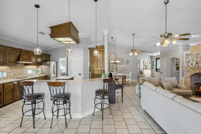 552 Heritage Ct, Canton, TX 75103 - kitchen featuring freestanding refrigerator, a kitchen breakfast bar, ornamental molding, backsplash, and custom exhaust hood