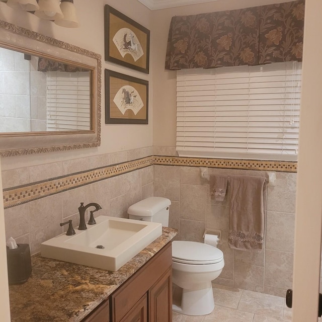 1509 W Hull St, Denison, TX 75020 - bathroom with toilet, tile walls, vanity, and wainscoting