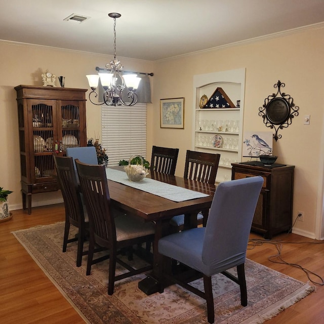 1509 W Hull St, Denison, TX 75020 - dining space featuring a chandelier, wood finished floors, crown molding, built in features, and baseboards