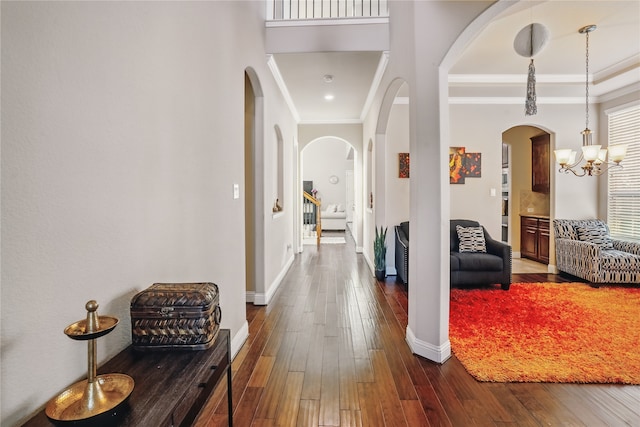 1001 Vineyard Dr, Euless, TX 76039 - hallway featuring crown molding, arched walkways, dark wood-style flooring, baseboards, and a chandelier