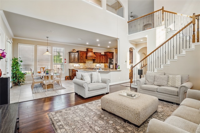 1001 Vineyard Dr, Euless, TX 76039 - living area featuring ornamental molding, light wood finished floors, stairway, baseboards, and arched walkways