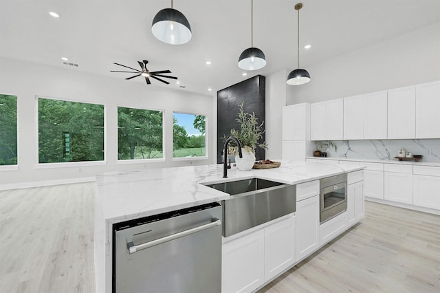 320 Bentwood Dr, Pottsboro, TX 75076 - kitchen with stainless steel appliances, a sink, light wood-type flooring, tasteful backsplash, and pendant lighting