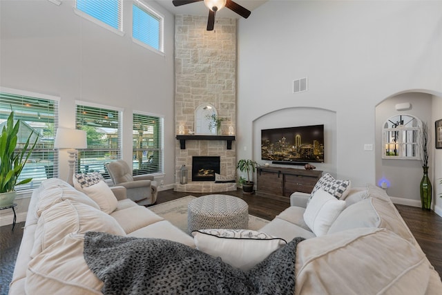 760 Ascot Ct, Prosper, TX 75078 - living area featuring a ceiling fan, a towering ceiling, baseboards, arched walkways, and a stone fireplace