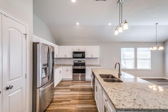 5520 Curzon Ave, Fort Worth, TX 76107 - kitchen with stainless steel appliances, a sink, lofted ceiling, an island with sink, and wood finished floors