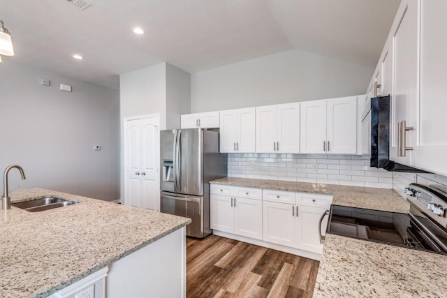5520 Curzon Ave, Fort Worth, TX 76107 - kitchen featuring appliances with stainless steel finishes, a sink, white cabinets, wood finished floors, and vaulted ceiling