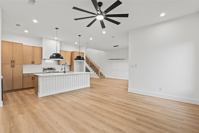2820 Barnes Bridge Rd, Dallas, TX 75228 - kitchen with stainless steel electric range, a ceiling fan, light countertops, recessed lighting, and a kitchen island with sink
