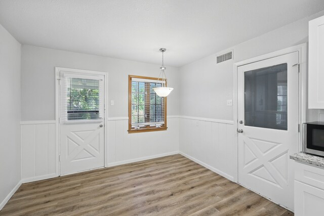4900 Vega Ct E, Fort Worth, TX 76133 - unfurnished dining area featuring wainscoting and light wood-style flooring