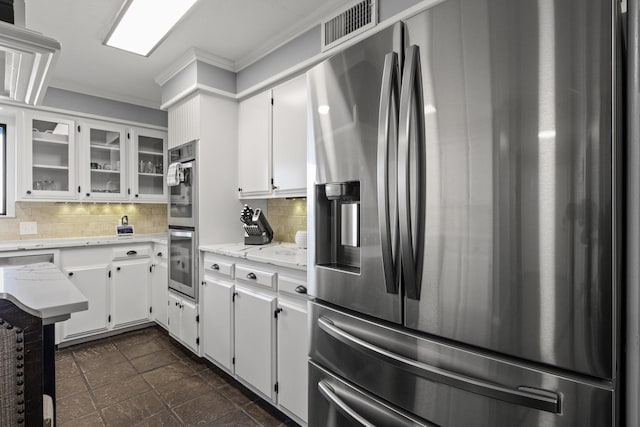 339 County Road 4315, Naples, TX 75568 - kitchen featuring appliances with stainless steel finishes, ornamental molding, tasteful backsplash, white cabinetry, and glass insert cabinets