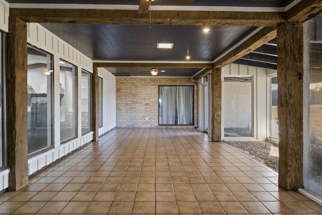 339 County Road 4315, Naples, TX 75568 - unfurnished sunroom featuring a ceiling fan, tile patterned flooring, and brick wall