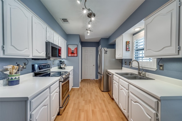 4500 Keys Dr, The Colony, TX 75056 - kitchen with stainless steel appliances, a sink, white cabinetry, light wood finished floors, and light countertops