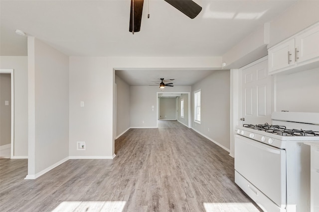 1822 Roberts Cut Off Rd, Fort Worth, TX 76114 - kitchen with a ceiling fan, white gas stove, light wood finished floors, and white cabinetry