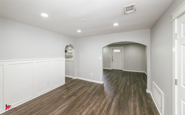 9472 Ranch Ln, Shreveport, LA 71106 - empty room with arched walkways, dark wood-style flooring, recessed lighting, and a wainscoted wall