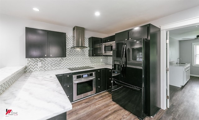 9472 Ranch Ln, Shreveport, LA 71106 - kitchen featuring black appliances, wall chimney exhaust hood, a sink, wood finished floors, and recessed lighting
