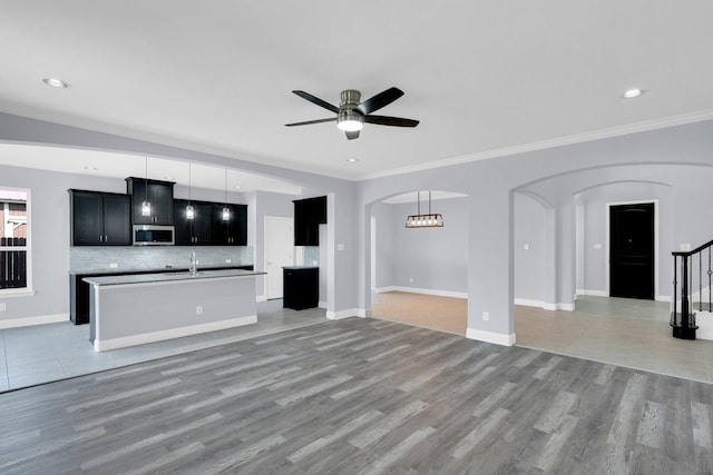 211 Debbie Way, Red Oak, TX 75154 - unfurnished living room featuring arched walkways, ceiling fan, light wood-style floors, ornamental molding, and baseboards