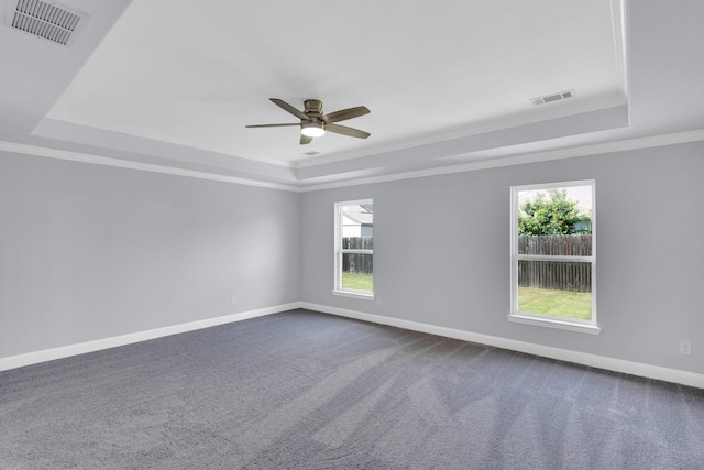 211 Debbie Way, Red Oak, TX 75154 - unfurnished room with a tray ceiling, ceiling fan, crown molding, plenty of natural light, and dark carpet