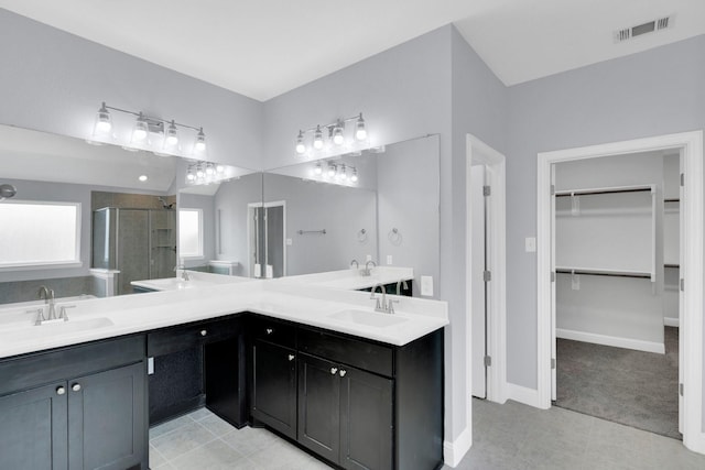 211 Debbie Way, Red Oak, TX 75154 - bathroom with a stall shower, a walk in closet, double vanity, and baseboards