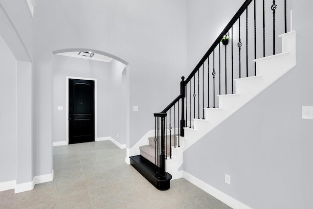211 Debbie Way, Red Oak, TX 75154 - tiled foyer with arched walkways, a towering ceiling, baseboards, and stairway