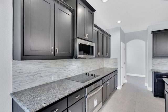 211 Debbie Way, Red Oak, TX 75154 - kitchen featuring appliances with stainless steel finishes, baseboards, decorative backsplash, light tile patterned floors, and light stone counters