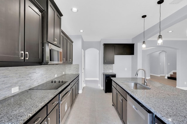 211 Debbie Way, Red Oak, TX 75154 - kitchen with arched walkways, a sink, stainless steel appliances, decorative backsplash, and light stone countertops