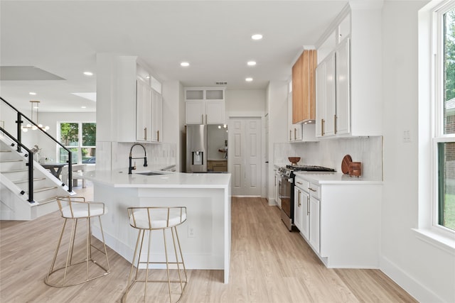 3717 Estacado Ln, Plano, TX 75025 - kitchen with appliances with stainless steel finishes, a peninsula, backsplash, a kitchen breakfast bar, and recessed lighting