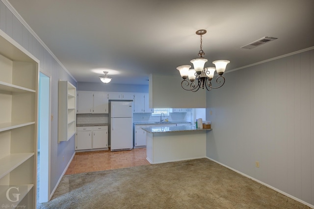 3422 Lanell Dr, Bossier City, LA 71112 - kitchen with freestanding refrigerator, a sink, light carpet, a peninsula, and a chandelier