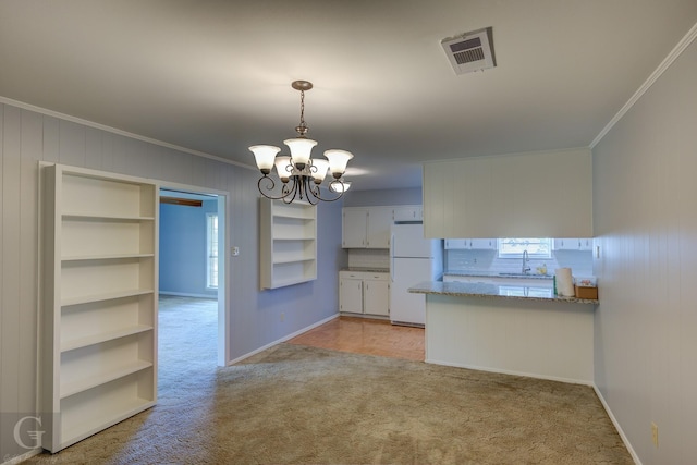 3422 Lanell Dr, Bossier City, LA 71112 - kitchen with freestanding refrigerator, a sink, ornamental molding, light colored carpet, and a chandelier
