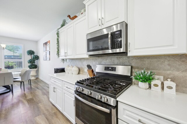 1816 Dunstan Dr, Fort Worth, TX 76052 - kitchen featuring appliances with stainless steel finishes, white cabinetry, tasteful backsplash, light countertops, and light wood finished floors