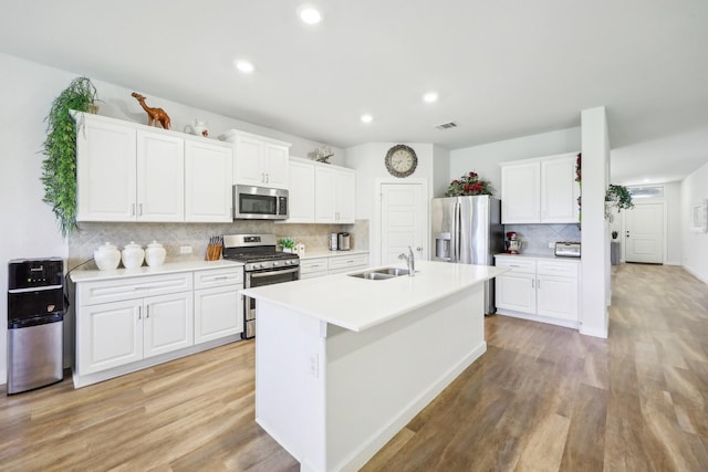 1816 Dunstan Dr, Fort Worth, TX 76052 - kitchen with appliances with stainless steel finishes, a sink, backsplash, light wood finished floors, and white cabinets
