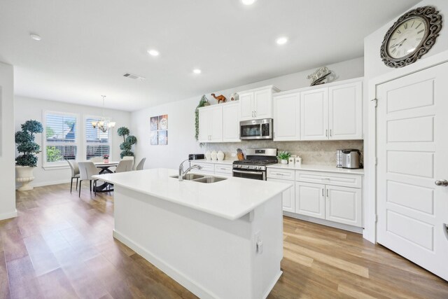 1816 Dunstan Dr, Fort Worth, TX 76052 - kitchen featuring appliances with stainless steel finishes, a sink, a chandelier, tasteful backsplash, and light countertops
