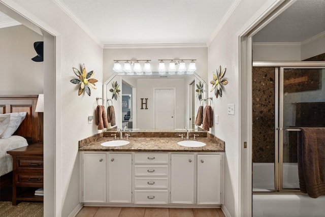 311 County Road 1710, Clifton, TX 76634 - full bath featuring double vanity, connected bathroom, crown molding, and combined bath / shower with glass door