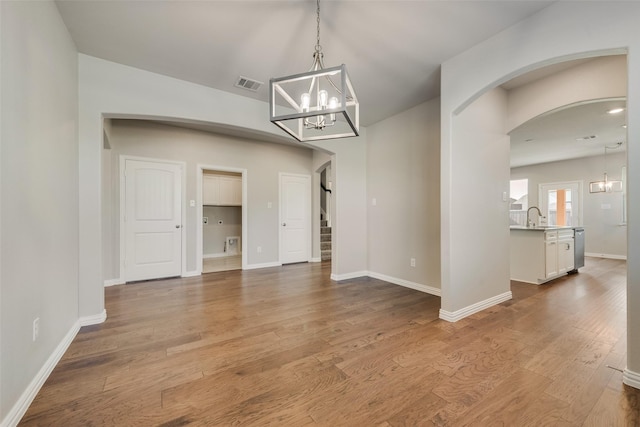 6314 Catalpa Dr, Venus, TX 76084 - unfurnished dining area with arched walkways, a chandelier, stairs, wood finished floors, and baseboards