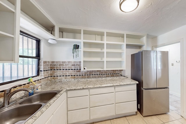6725 Lovett Ave, Dallas, TX 75227 - kitchen with open shelves, freestanding refrigerator, a sink, white cabinets, and light tile patterned floors