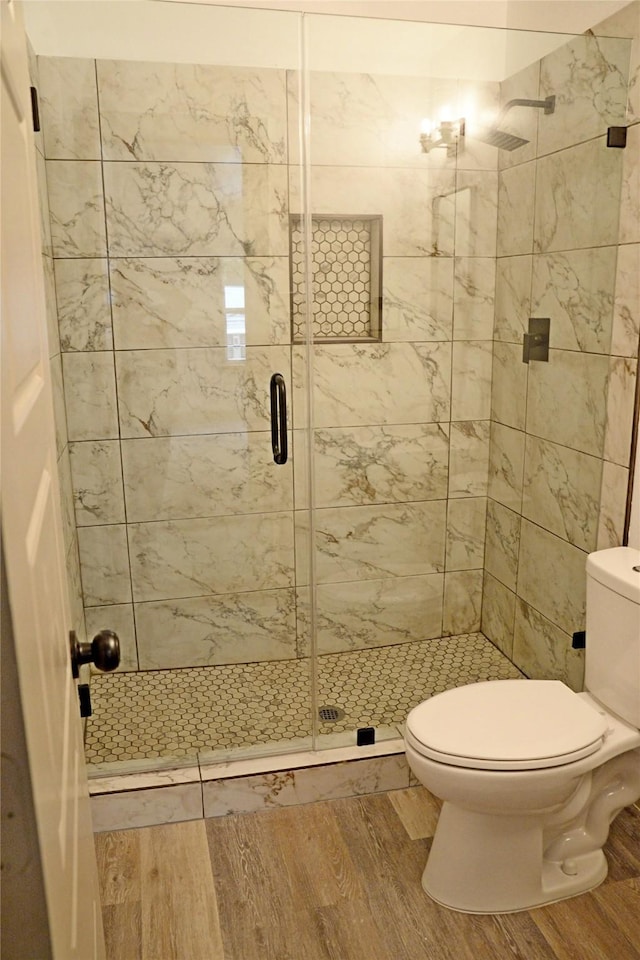 7810 Larchridge Dr, Dallas, TX 75232 - full bath featuring wood finished floors, a shower stall, and toilet