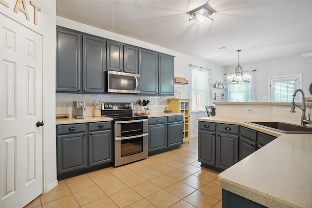 4604 Fox Sedge Ln, Denton, TX 76208 - kitchen with appliances with stainless steel finishes, gray cabinetry, a sink, tasteful backsplash, and healthy amount of natural light