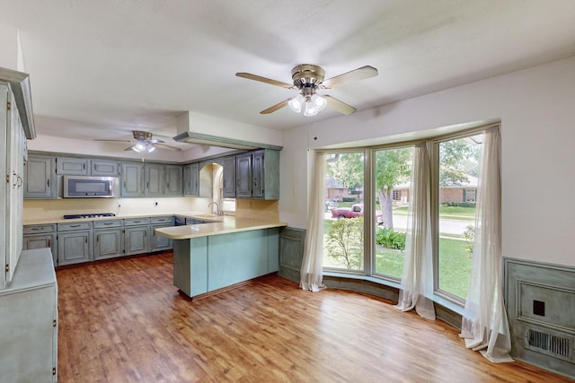 1308 Warwick St, Garland, TX 75040 - kitchen featuring stainless steel microwave, ceiling fan, a peninsula, gray cabinets, and a sink
