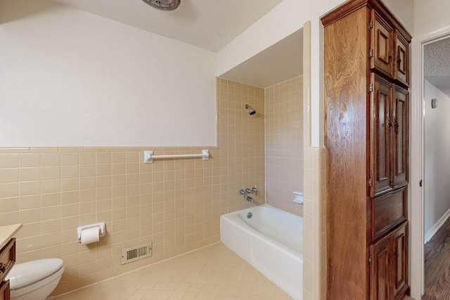 1308 Warwick St, Garland, TX 75040 - bathroom with washtub / shower combination, toilet, vanity, and tile walls