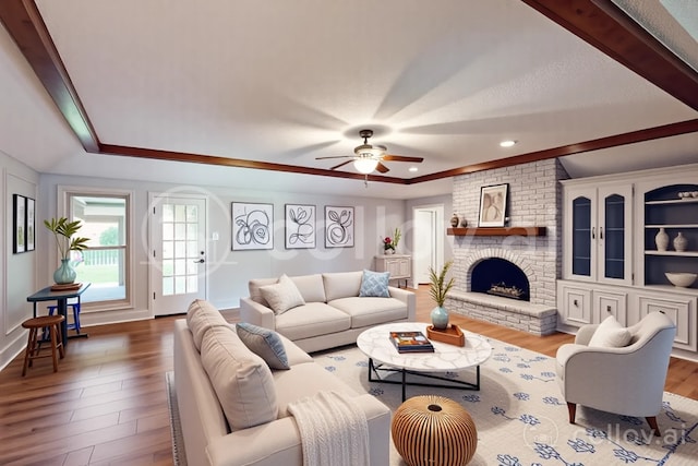 1308 Warwick St, Garland, TX 75040 - living area with a raised ceiling, wood finished floors, ceiling fan, a fireplace, and ornamental molding
