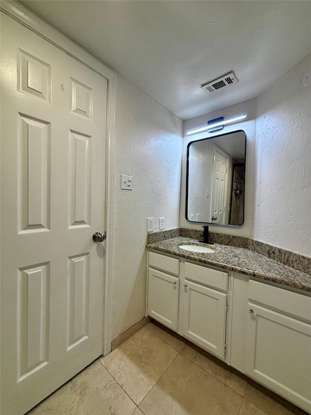 6108 Abrams Rd Unit 601, Dallas, TX 75231 - bathroom with tile patterned flooring, vanity, baseboards, and a textured wall