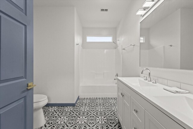 4706 Spring Ave, Dallas, TX 75210 - bathroom with toilet, double vanity, baseboards, and bathtub / shower combination